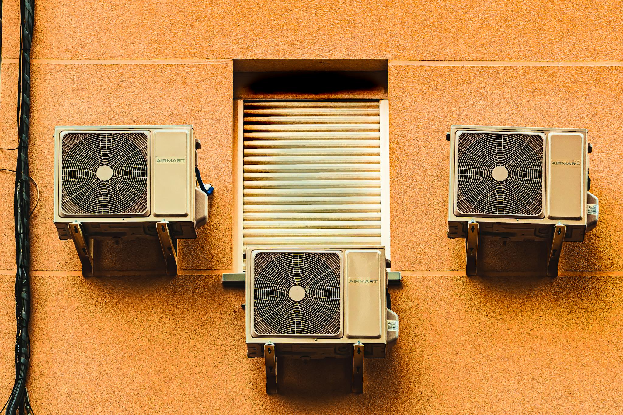 Exterior wall with three air conditioners, showcasing modern architectural elements.